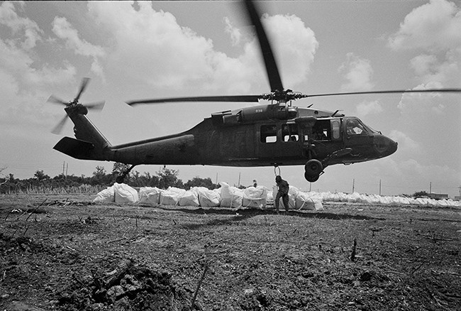 National Guard helicopters drop 3000-lb. sandbags to build up an artificial berm. 